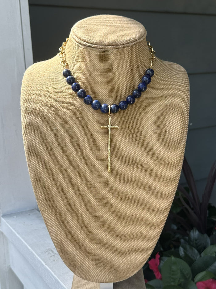 Elegant bead and chain necklace featuring rich lapis beads paired with delicate open gold chain. The centerpiece showcases a long, hammered cross pendant with beautiful texture and dimension. A sophisticated piece that combines natural stone beauty with refined metalwork for a timeless look.
Approximate length: 19-21"