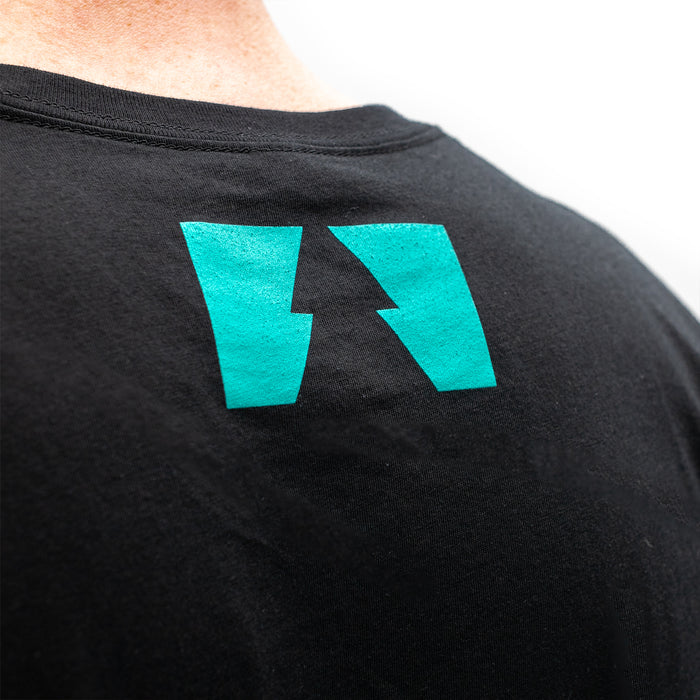 A closeup of a logo of a tree on the top of the back of a a black shirt.