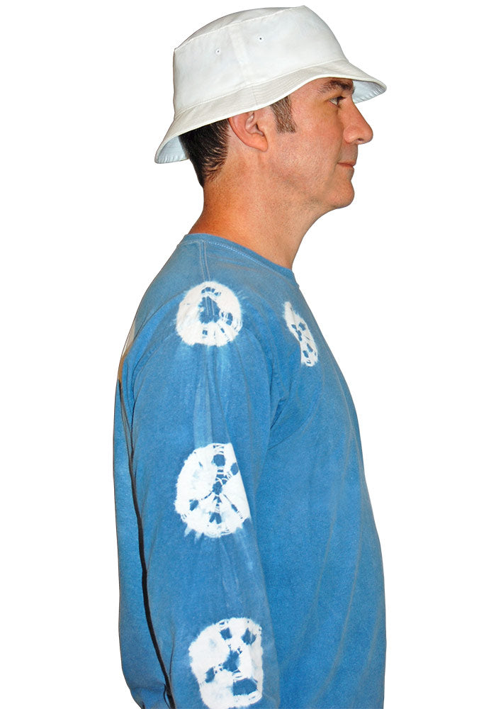 Side view of man wearing a blue shirt with white patterns and a white bucket hat on a white background.