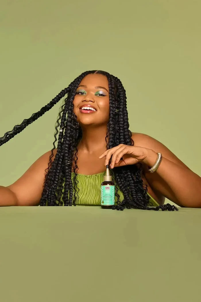 Lifestyle photo of model with long braids featuring African Pride Feel It Formula Strengthening Oil – Stimulating Scalp Oil
