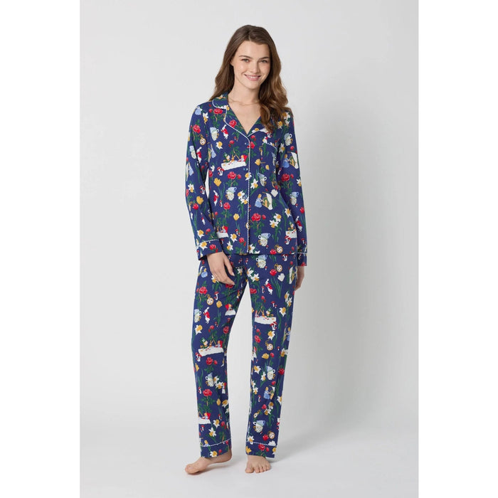 Woman wearing a blue pajama set with Alice in Wonderland print on a white background