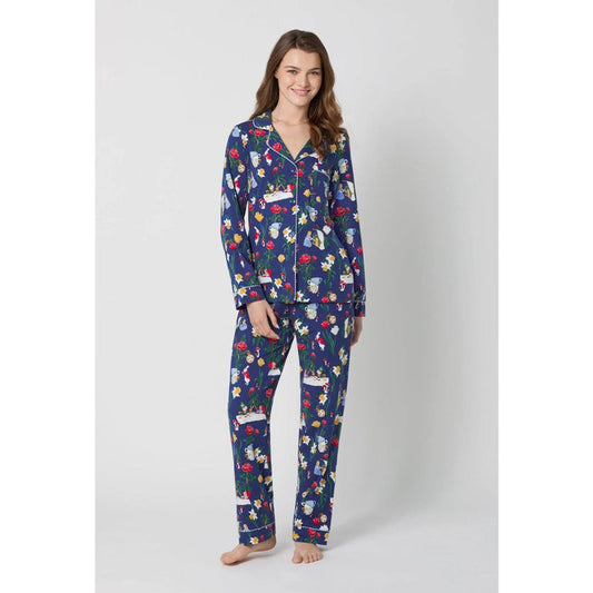Woman wearing a blue pajama set with Alice in Wonderland print on a white background