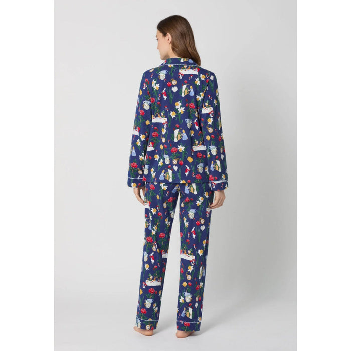 Woman wearing a blue pajama set with Alice in Wonderland print on a white background