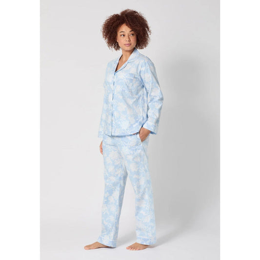 Woman wearing a light blue pajama set with a white background
