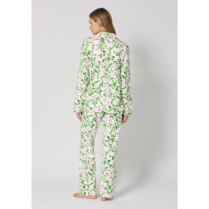 Woman wearing a floral pajama set on a plain background
