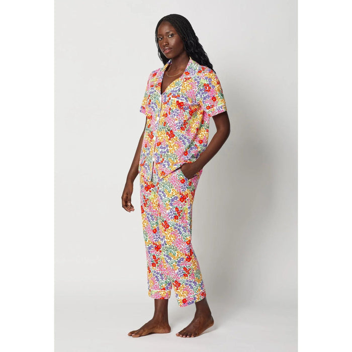 Woman wearing a colorful floral pajama set on a white background
