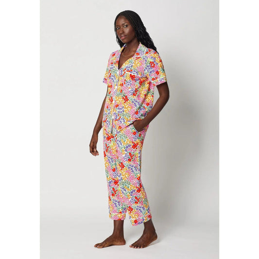 Woman wearing a colorful floral pajama set on a white background