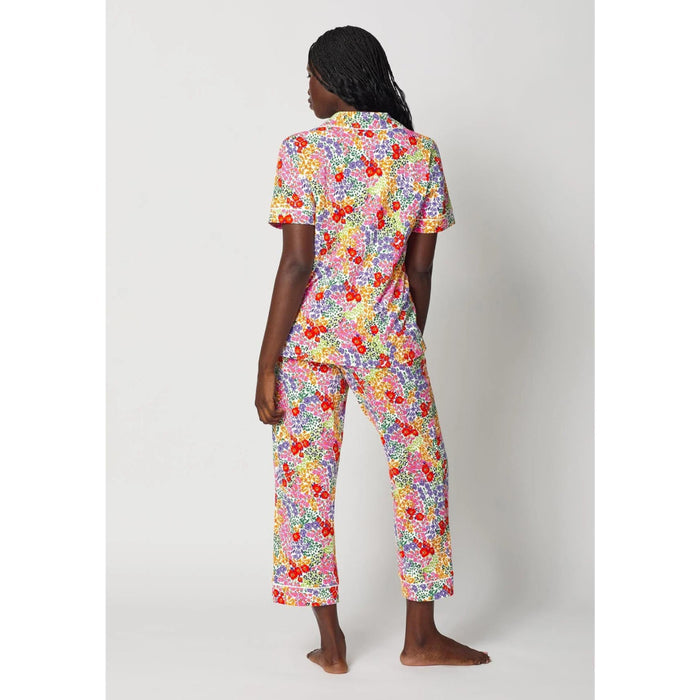 Person wearing a colorful floral pajama set on a white background