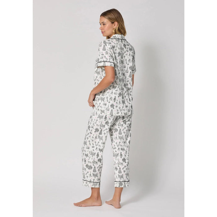 Woman wearing a patterned pajama set on a plain background
