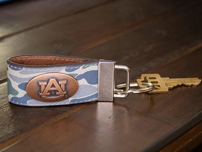 Carry your school pride with these collegiate "old school" licensed key chains. Crafted from full grain leather, each fob features an oval logo on the front with an antique copper metal emblem that adds timeless elegance.

Designed to hold multiple keys comfortably, the natural leather construction pairs beautifully with the detailed metal accent. Perfect for graduation gifts, birthdays, groomsmen favors, or any special occasion, this key fob celebrates your alma mater in style and will remain a cherished k