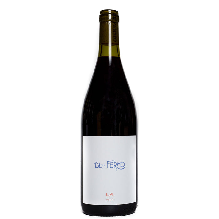Red wine bottle with white label and blue "DE FERMO" text