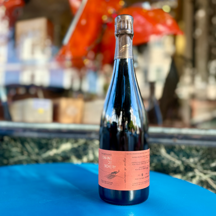 Brut nature sparkling wine bottle with silver foil top and pink label