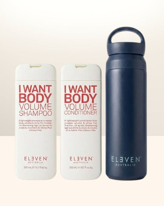 Two bottles of 'I Want Body Volume' shampoo and conditioner by Eleven Australia, with a navy water bottle - Hair Care Canada