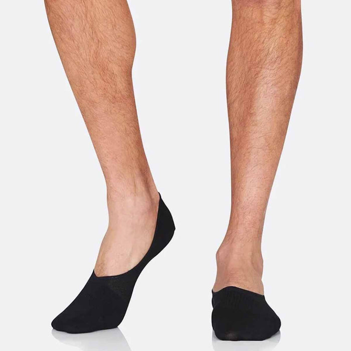 Black liner socks modelled on a male's feet.