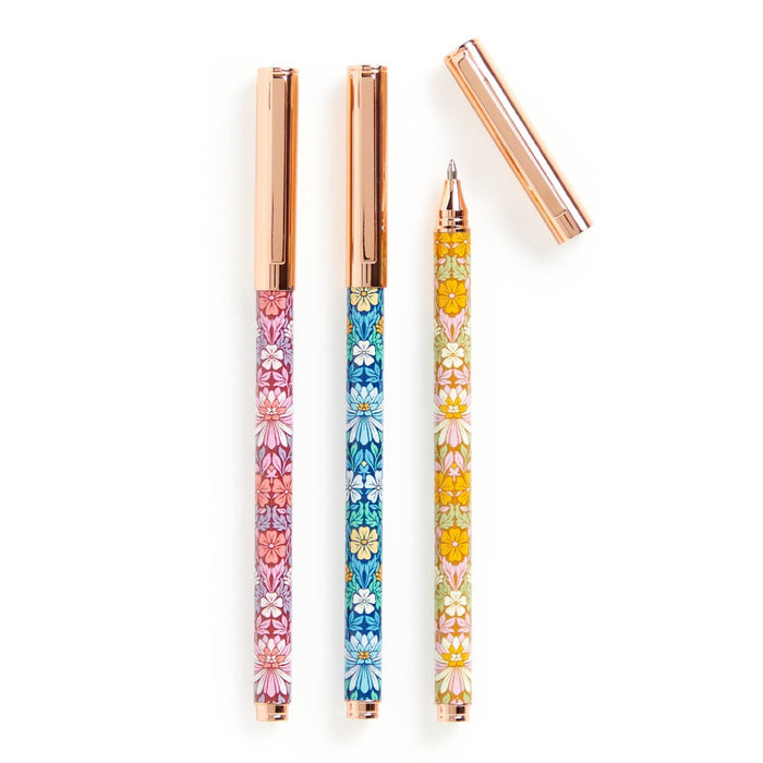 Three floral-patterned pens with rose gold accents on a white background