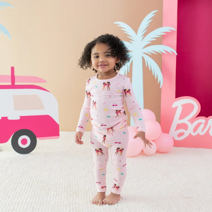 Kyte Baby Barbie™ Beach girls pajama set with long sleeves, matching pants, and playful pink print.