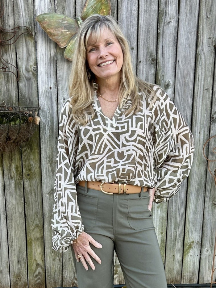 This lightweight long sleeve top is your go-to transition piece for any season. The rich olive base adorned with a subtle beige pattern offers understated elegance that pairs with everything in your closet. The ruffled v-neckline brings a touch of refinement, while full sleeves finished with elastic cuffs ensure a comfortable, flattering fit. This lovely top transitions beautifully from winter to spring.

Material: 85% Rayon / 15% Nylon

Care Instructions: Gentle cool hand wash, dry flat