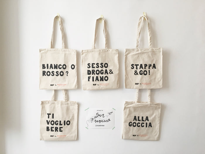 Set of off-white canvas tote bags with long handles and printed phrases