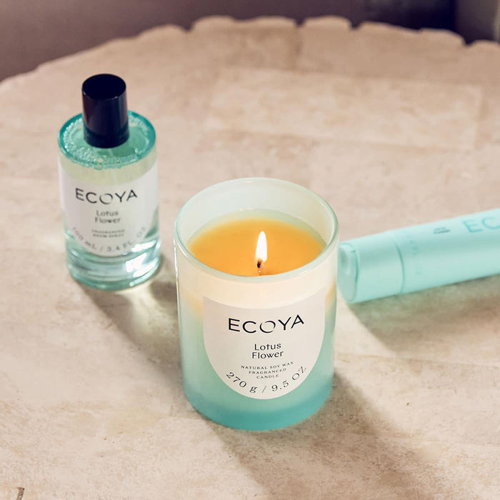 ECOYA Lotus Flower candle and bottle on a textured surface.