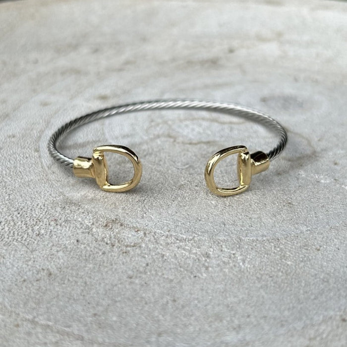 Effortless elegance meets versatile style with this mixed metal cuffed bracelet. Crafted in warm gold and cool silver tones, the design features a distinctive stirrup accent that adds visual interest to any wrist. The flexible, bendable construction ensures a comfortable fit for most sizes, while the cuff style makes it simple to slip on and off. Layer it with other pieces or wear it solo for an understated, sophisticated look.

Note: Silver N' Accessories jewelry is brass and stainless steel with rhodium a