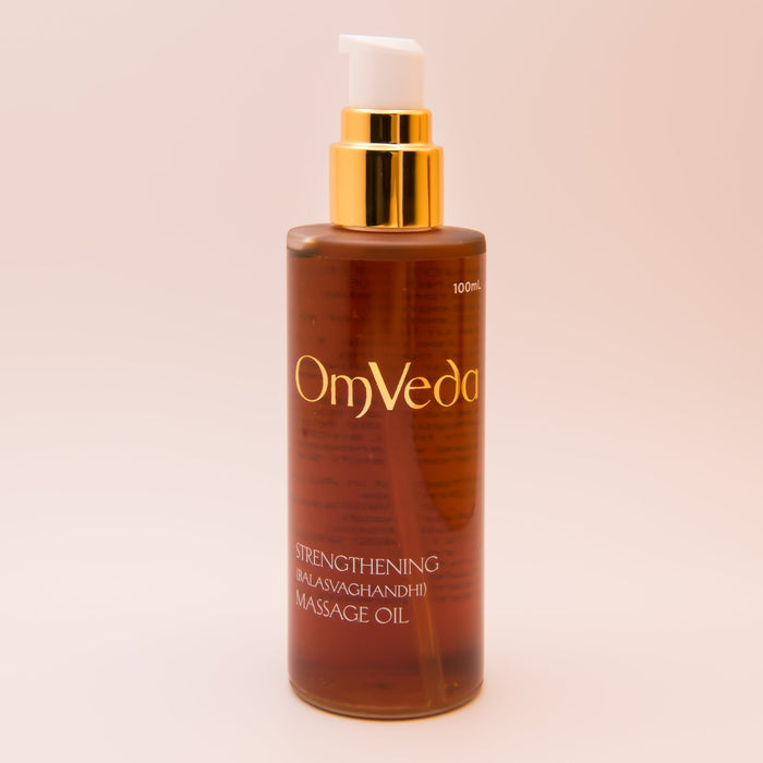 OmVeda strengthening body oil bottle, amber liquid with gold pump, 100 ml