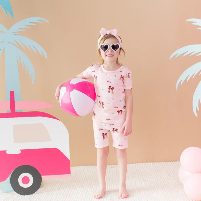 Girl wearing Kyte Baby Barbie™ Beach short sleeve pajamas in soft breathable bamboo fabric.