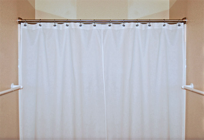 White 100% cotton fair-trade shower curtain hanging on a shower rod in a cream bathroom.