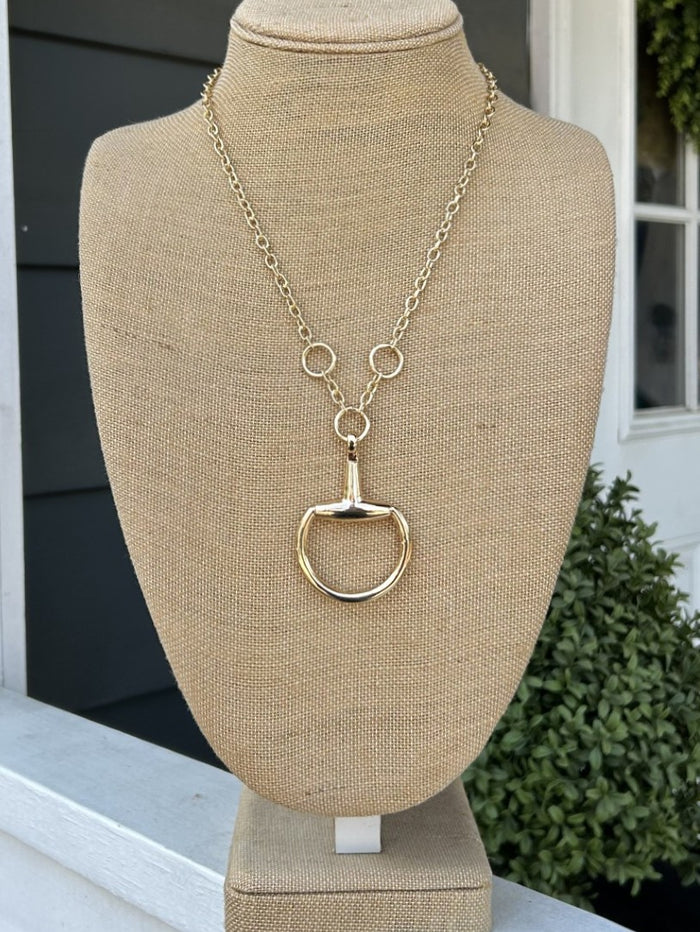 This elegant chain necklace celebrates equestrian passion with a beautifully crafted boot pendant anchored by three lustrous gold rings. The classic chain link construction pairs seamlessly with the medium length, creating a versatile piece that transitions effortlessly from casual to formal settings. Perfect for riders and horse enthusiasts seeking a refined way to express their love of the sport.

Approximate Length: 22"

Note: Silver N' Accessories jewelry is brass and stainless steel with rhodium and 18