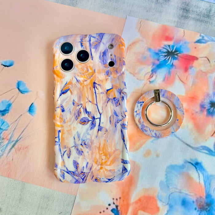 Where Dreams Bloom MagSafe grip ring shown beside the matching Where Dreams Bloom iPhone case on a soft floral paper background.