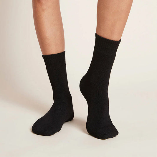 A pair of black, women's crew boot socks modelled on feet.